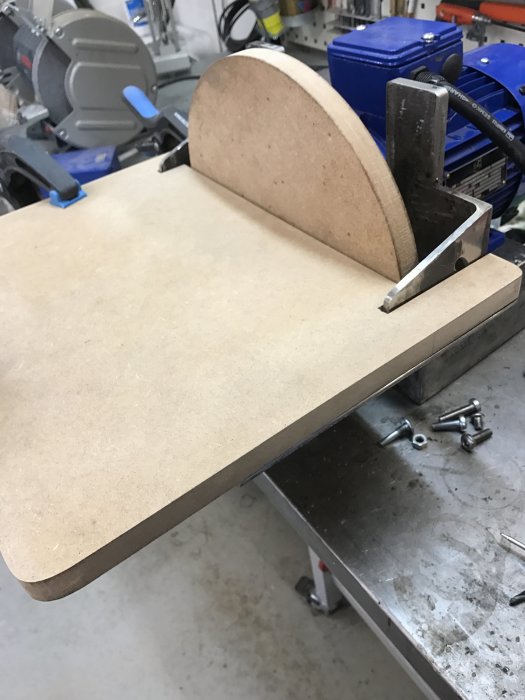 MDF-bord och halvcirkelformad tallrik i prototyp till tiltbart bord, med synlig spalt efter lutning.