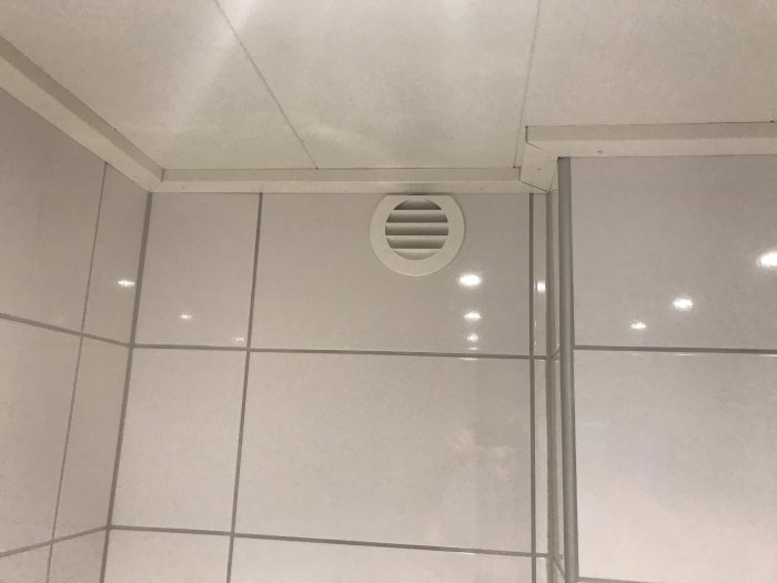 Nymonterade vita taklister och ventilation i ett kaklat badrumstak.