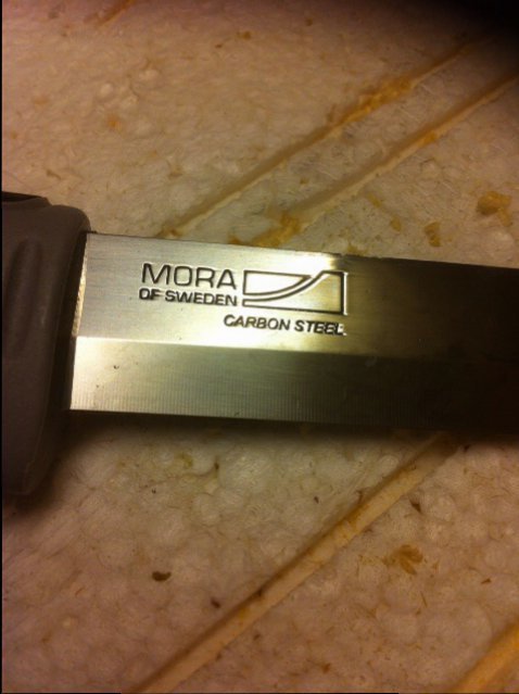 Närbild på en Mora-kniv med texten "MORA of Sweden CARBON STEEL" på bladet.