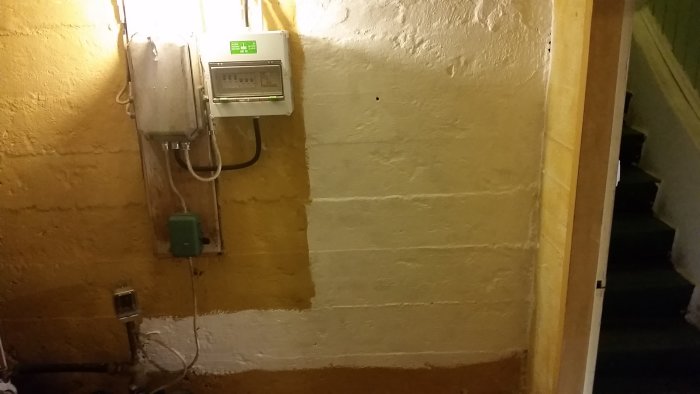 Recently painted wall with electrical fuse box and meter, prepped for installation work.