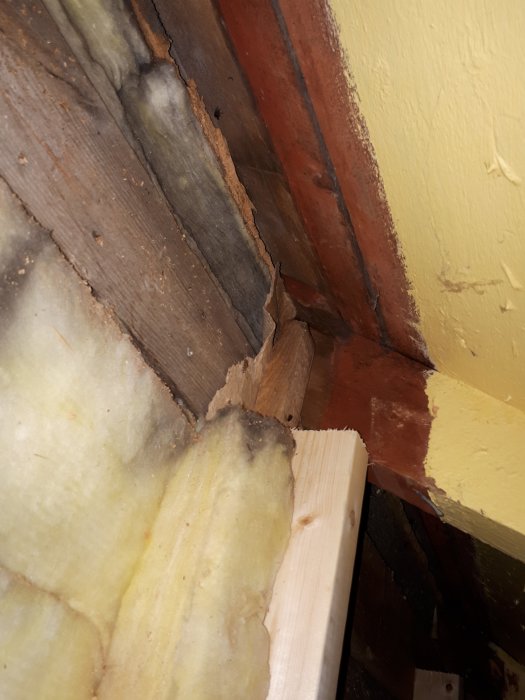 Vindduk fästad i undertak intill isolermaterial och träreglar, med inredning synlig.