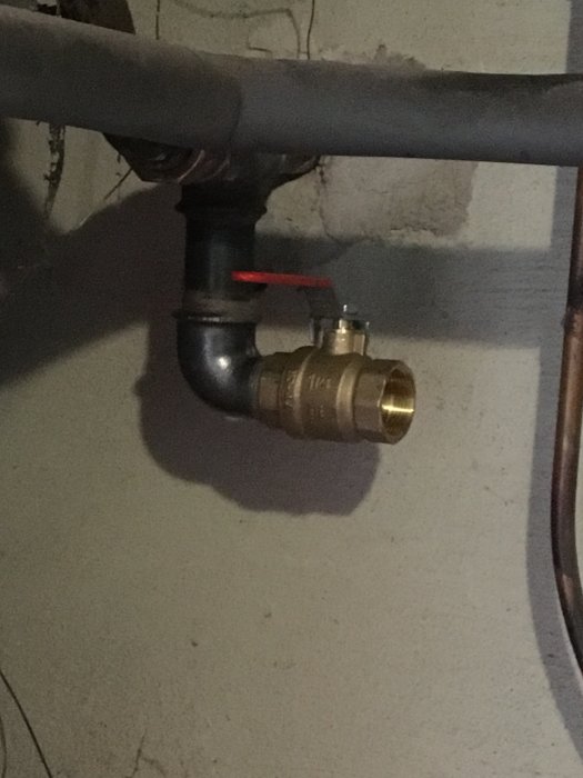 Ventil installerad på ett järnrör för att köra värmesystem på el, i ett pannrum.