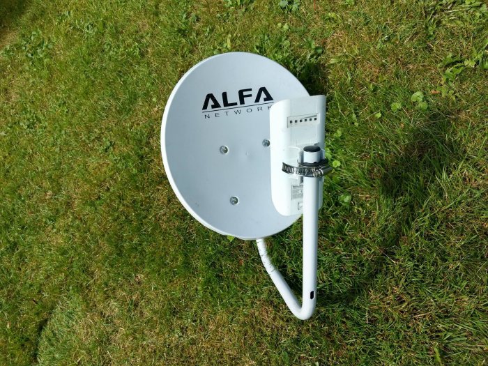 En Alfa Network parabolantenn för wifi-signalförstärkning monterad på gräsytan.