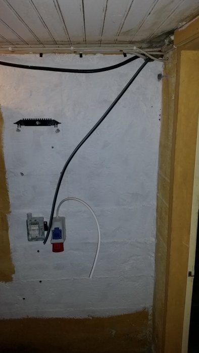 Elkablar dragna längs vägg utan klammer, gammal normcentral och en oisolerad kabel.