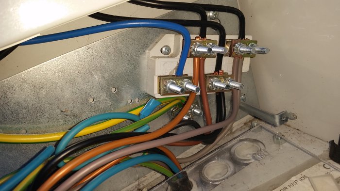 Elektrisk plint med anslutna neutralledare och kablar i olika färger i ett öppet elskåp.