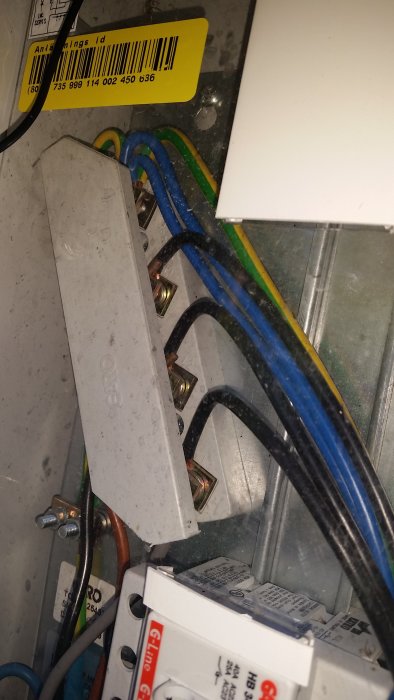 Elcentral med öppet skydd visar kablar anslutna till plintar och säkringar.