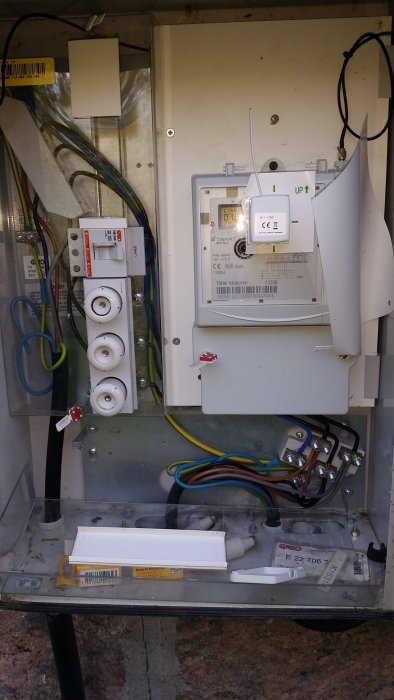 Elcentral med öppet skydd visar kopplingar, plintar, jordfelsbrytare och energimätare i en installation.
