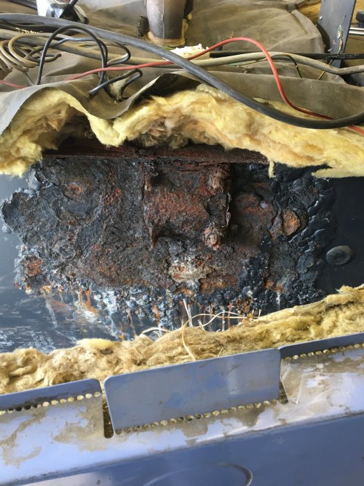 Rostskador och vattenläckage på sidan av en uppackad värmepanna