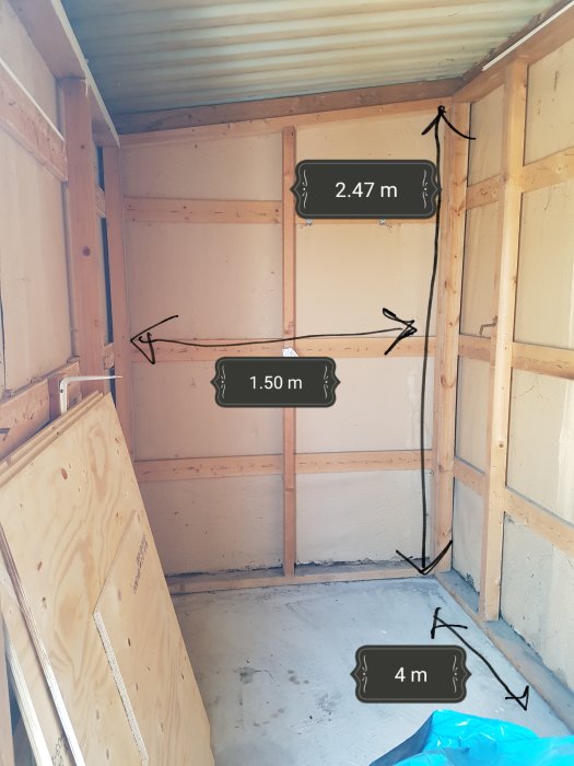 Interiör av ett litet ouppvärmt förråd med plåtväggar och träreglar, märkt med mått för isoleringsprojekt.