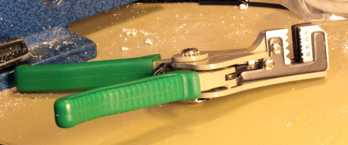 En tång med gröna handtag och storleksguide markerad 1.6 på en dammig yta.