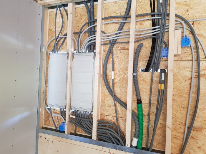 Installationsvägg med kabeldragning för data, larm och el, inklusive fördelningsskåp för el och KNX-system.