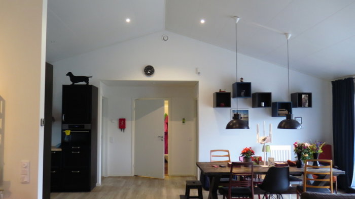 Modern inredning av ett kök och matrum i anslutning till en hall med synlig tapet Atmosphere III.