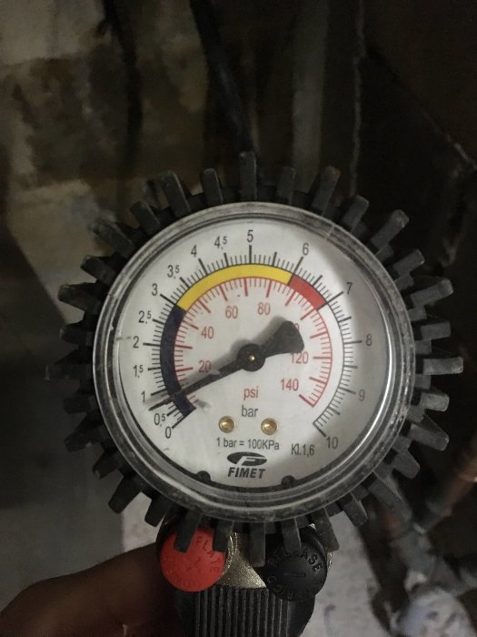 Manuell tryckmätare i handvisning med skala i psi och bar, synlig visare på ca 3 bar.