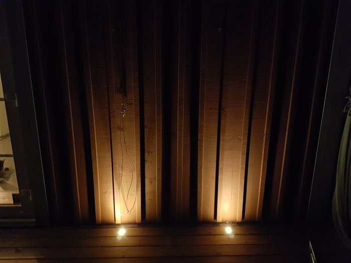 Installerade Cosa 45 lampor lyser upp på en träaltan under kvällstid.
