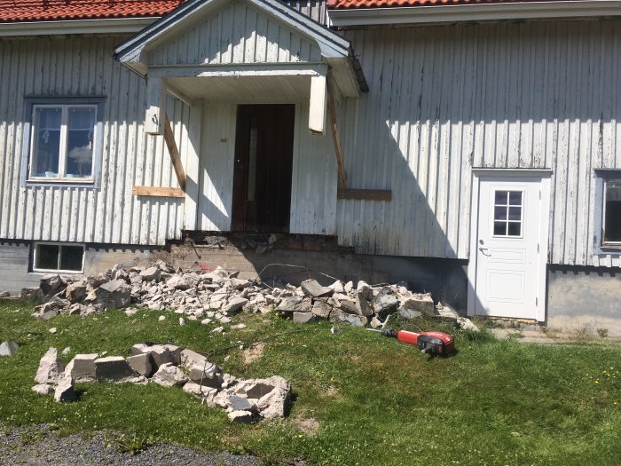 Renoveringsarbete på hus, riva tak, hopa frigolit och byggavfall framför huset.