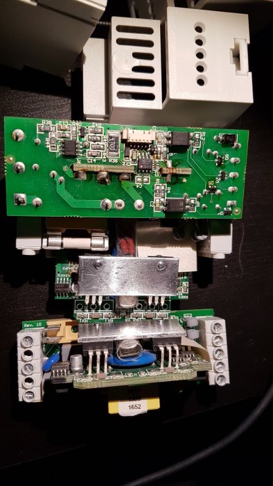 Två isärtagna elektroniska dimrar med exponerade kretskort och komponenter för DIN-skenmontering.