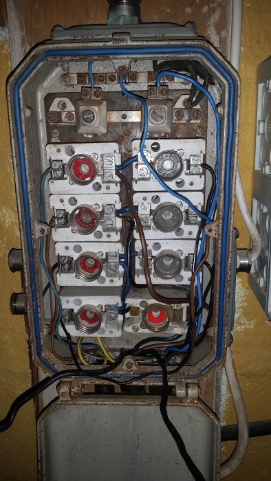 Gammal elcentral med oanslutna ledningar och demonterade säkringar i behov av renovering.