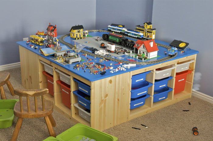 Lego-bord byggt av IKEA Trofast stommar med tågbana, byggnader, och förvaringslådor under.