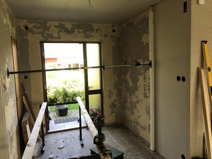 Renoveringsprojekt med en nyligen uppsatt gipsskiva och pågående arbete i ett rum.