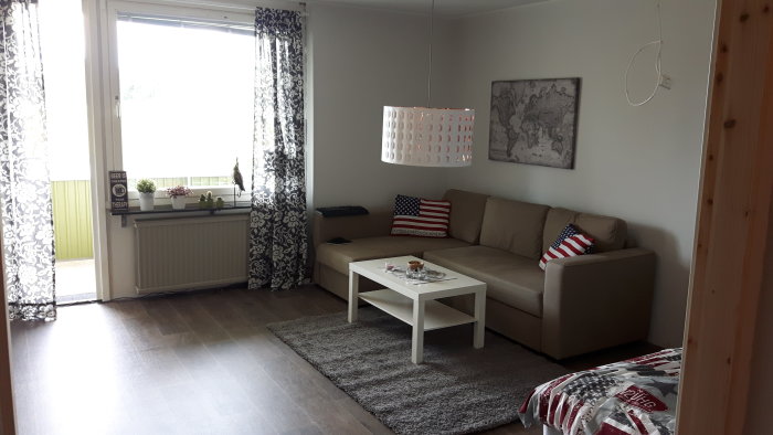 Renoverat vardagsrum nästan klart med soffa, bord, matta och ej färdigställd elektrik.