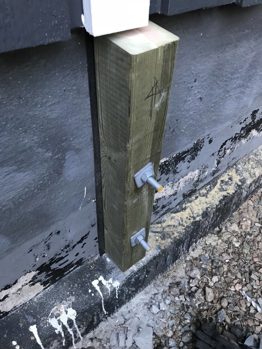 Träpelare 95x95 fäst i svartmålad betonghålsten med bultar utan papp emellan.