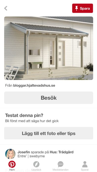 Ett vitmålat hus med ett skärmtak över entrén som stöttas av fyra pelare.