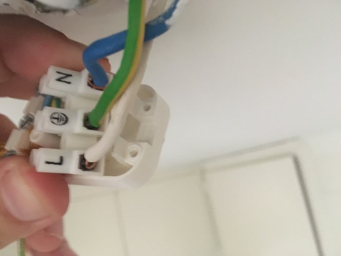 Närbild på elektrisk anslutning för taklampa med kopplade sladdar i takdosa.