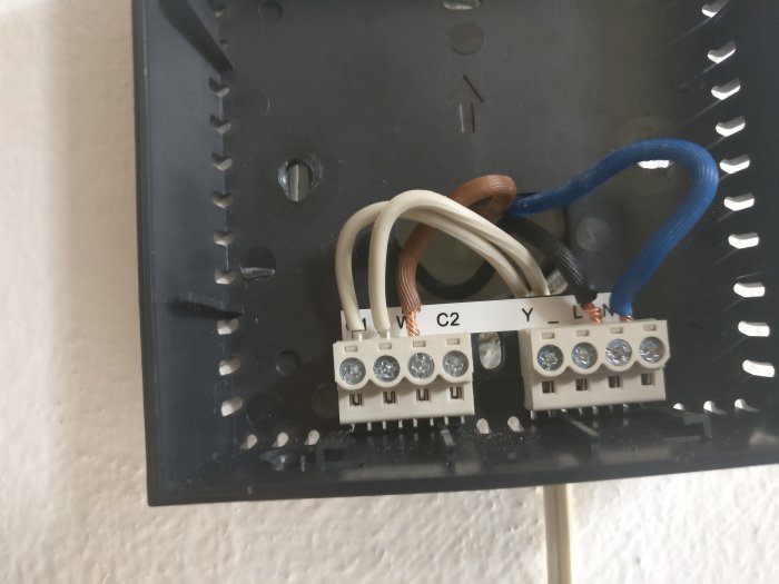 Installation av termostat med vita ledningar i C-terminalen och 24VAC adapterkablar.