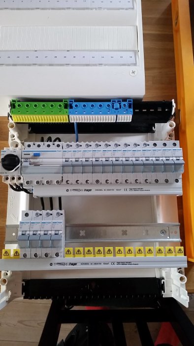 Elcentral före installation med säkringsdosor och ledningsklämmor, mot en hemmabakgrund.