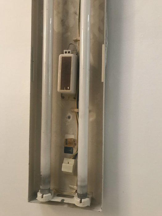 Interiörbild av öppen elkanal med synliga ledningar och elkomponenter i en vägg.