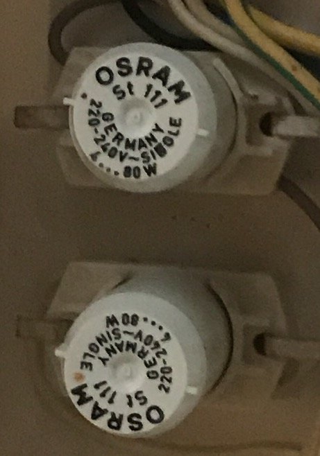 Två Osram SI 11 glimtändare för lampor, monterade i en ljusarmatur.