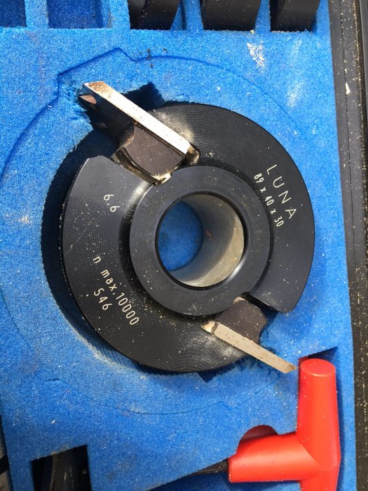 Närbild på en kutter med tekniska specifikationer, förvarad i blått skumgummi.