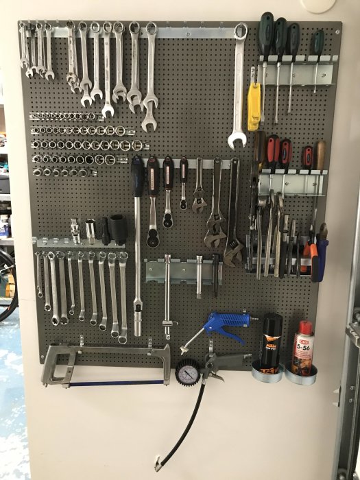 Verktygstavla med organiserade verktyg inklusive skiftnycklar, skruvmejslar och tänger.