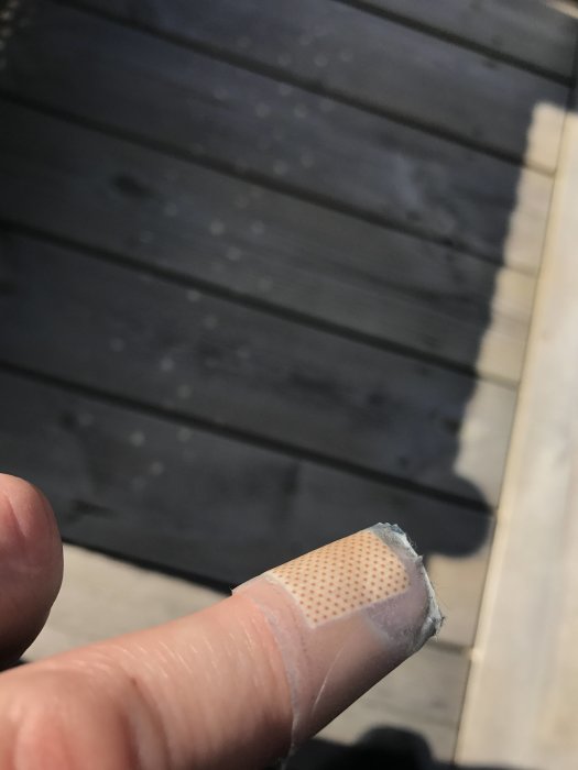 Någons finger med ett plåster och små skador, antyder problem vid byte av robotklipparknivar.