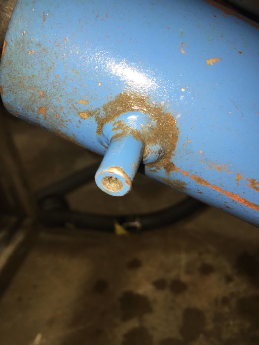 Närbild på en lyftkolvs nippel med rost och smuts, antydan om möjlig backventil inuti.