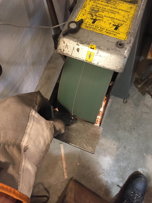 Hand i skyddshandske håller i en metallcylinder med ny löstagbar infästning i verkstad.