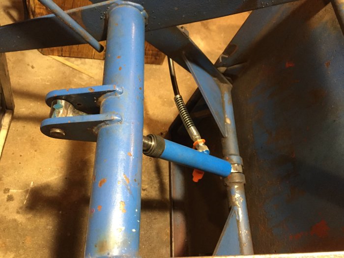 Delar av en blå metallstruktur med rostfläckar som ska omvandlas till ett svetsbord.