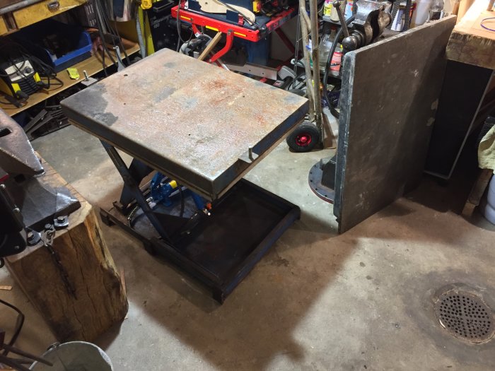 Rostig metallplatta på svetsbord i verkstad väntar på renovering och uppgradering.
