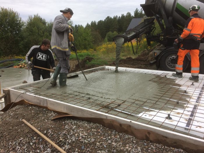 Arbetslag som gjuter en betongplatta med armeringsjärn, cellplast och stödstrukturer.