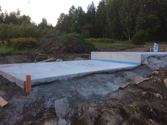 Betongplatta med dilatationsfog och armerade L-stöd i byggmiljö.