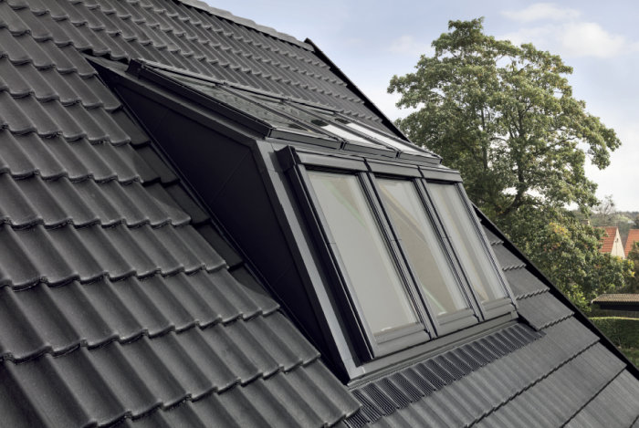 Stor Velux takkupa installerad på ett tegeltak, visar exempel på avväxling av takstolarna.