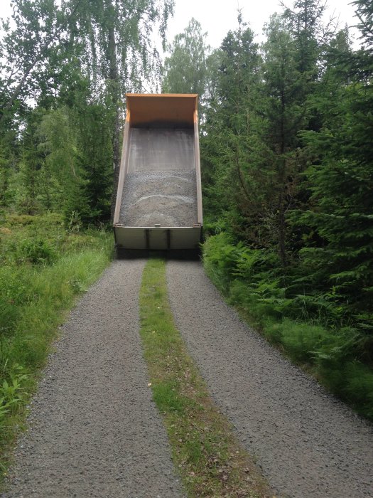 Lastbil tippandes grus på skogsväg 13 mil norr om Stockholm.