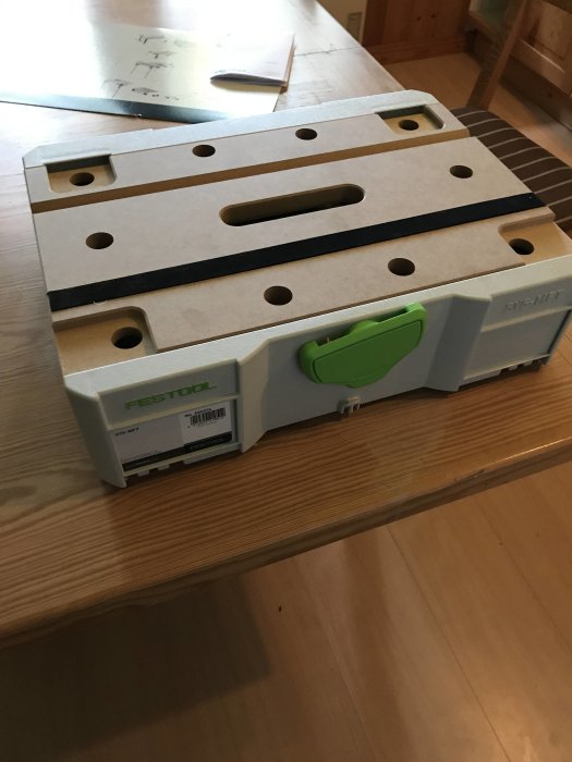 Festool skensågsläde för sänksåg placerad på ett bord, utformad för att underlätta kapning.