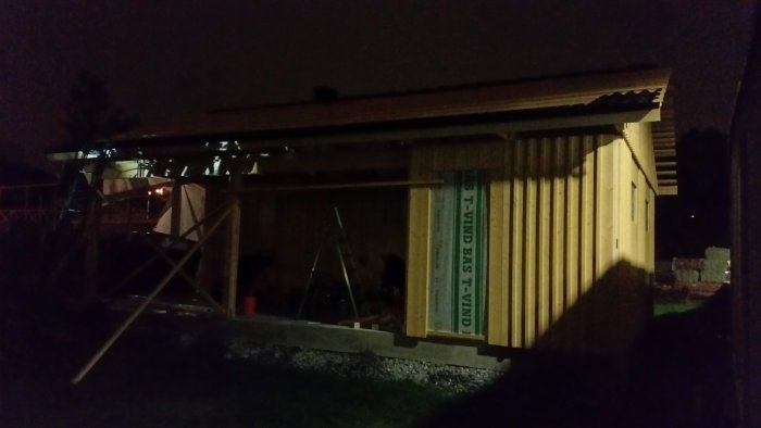 Nybyggt hustak på kvällen med spikade takreglar och nedersta raden av takpannor.