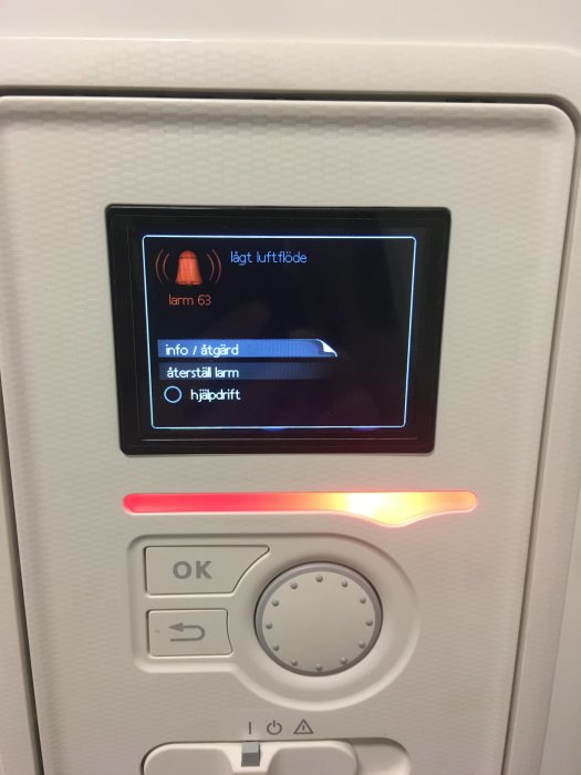 Frånluftsvärmepumpens display visar ett felmeddelande om lågt luftflöde med en röd varningslampa tänd.