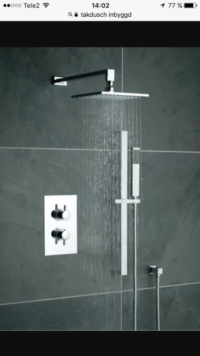 Modern inbyggd takdusch med rinnande vatten på en grå kaklad vägg, inklusive termostatblandare.