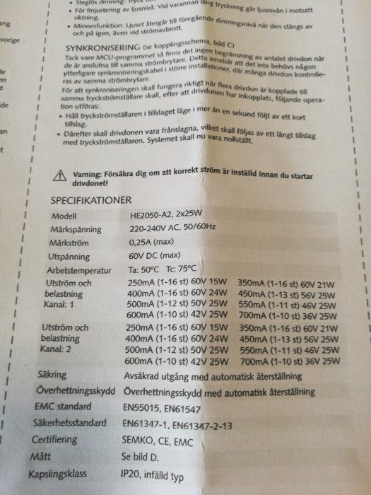 Närbild av teknisk specifikation för en belysningsdrivare med modellnummer, elektriska värden och säkerhetsstandarder.