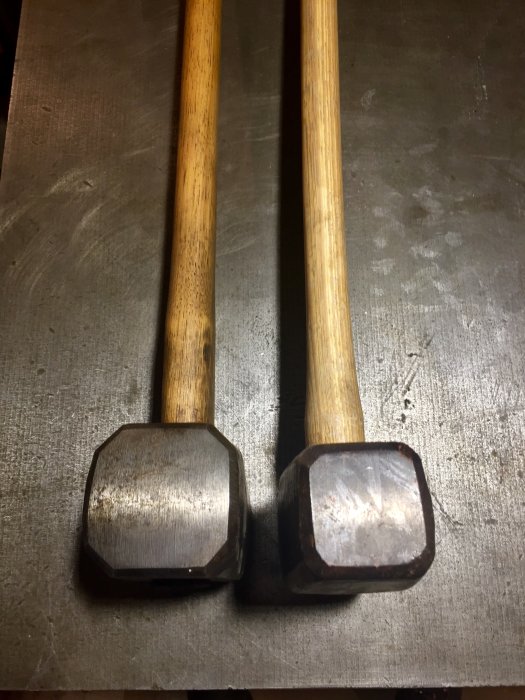 Två 5-kg släggor, en slank 'Tor' och en satt 'Hults', på en metallisk yta.