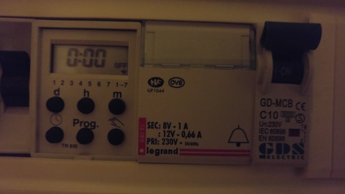 Elektrisk panel med Legrand timer och strömbrytare, siffror och symboler synliga.