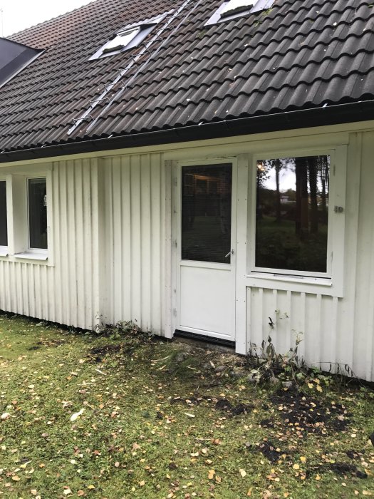 Altandörren och fönster på en husfasad, nysågade för att byta plats i en renoveringsprocess.